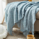 plaid tricoté jacquard à pompons motif carreaux salon